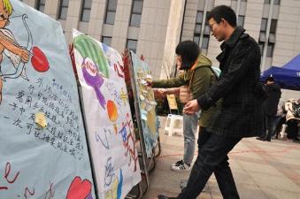 大學生寫下心愿,貼在心愿墻上 大學生寫下心愿,貼在心愿墻上